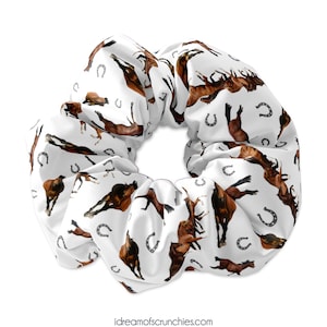 May include: White scrunchie with a repeating pattern of brown horses and silver horseshoes.