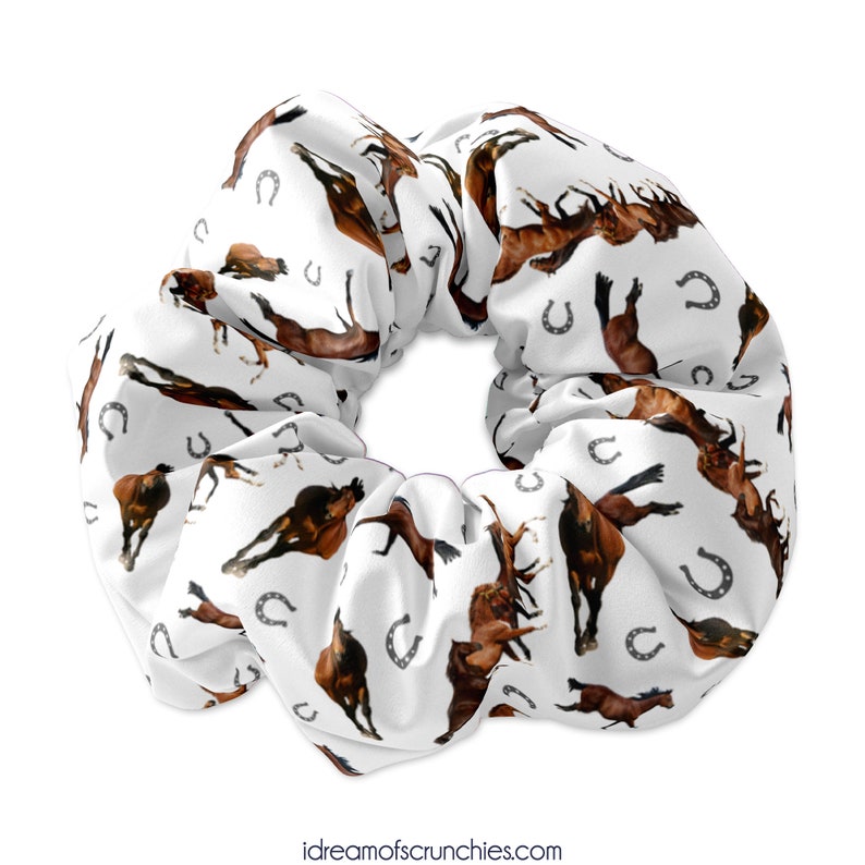 May include: White scrunchie with a repeating pattern of brown horses and silver horseshoes.