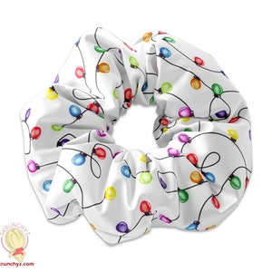 Könnte beinhalten: Ein weißer Scrunchie mit einem bunten Lichterkettenmuster.