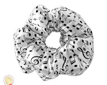 May include: White scrunchie with a black and white musical note pattern.