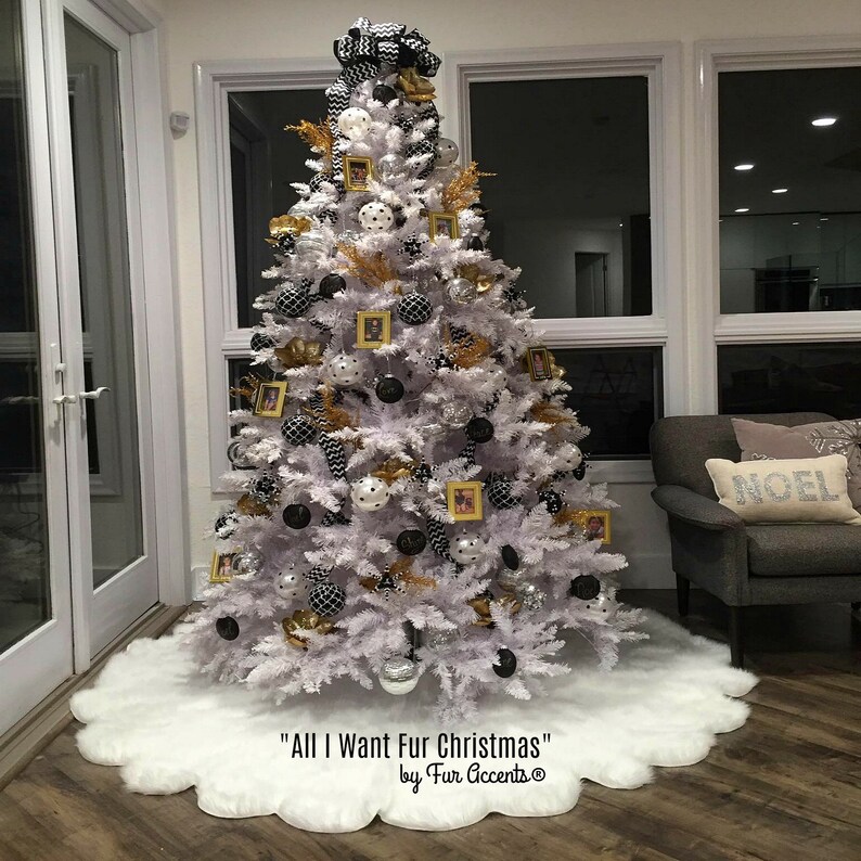 May include: White Christmas tree decorated with black and white ornaments, gold ribbon, and framed photos. The tree is on a white faux fur tree skirt. The text "All I Want Fur Christmas" and "by Fur Accents" is at the bottom of the image.