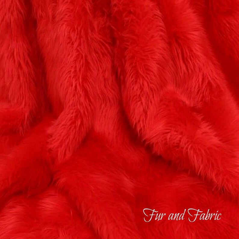 May include: Close-up of a bright red faux fur fabric. The fur is soft and fluffy, with a long pile. The fabric is perfect for crafting projects, clothing, and home decor.