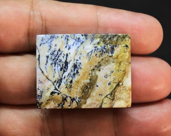 May include: A rectangular dendritic agate gemstone featuring a polished surface with a creamy white and golden yellow base, accented by intricate, dark black fern-like inclusions that spread across the stone in a branching, organic pattern.