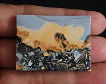 Puede incluir: Una losa pulida de ágata colorida con un patrón azul, amarillo y negro. La ágata tiene una superficie lisa y pulida y es una piedra natural.
