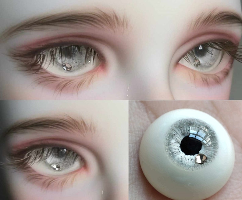 May include: Close-up of a pair of realistic doll eyes with a silver glitter effect. The eyes are set in a doll's head and have a white sclera and a black pupil. The eyes are surrounded by eyelashes and a light pink eyelid.
