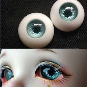 May include: Two blue doll eyes with silver glitter. The eyes are on a white background.