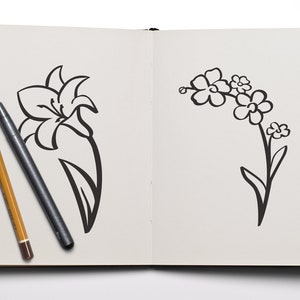 K&ouml;nnte beinhalten: Ein Skizzenbuch mit zwei Schwarzwei&szlig;-Zeichnungen von Blumen. Die linke Seite zeigt eine Lilie und die rechte Seite einen Strau&szlig; Vergissmeinnicht.