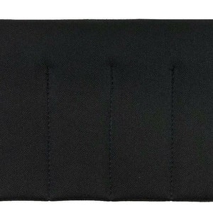 May include: A rectangular, black fabric item with vertical stitched lines. The item has a textured surface and appears to be a case or cover. The edges are neatly finished with a black border.