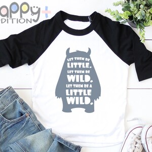 以下が含まれることがあります： 白と黒のベースボールTシャツに、グレーのモンスターのシルエットと「Let them be little. Let them be wild. Let them be a little wild.」というテキストがプリントされています
