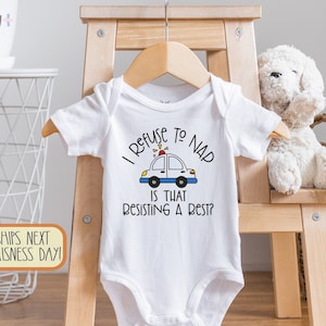 Può includere: Body bianco per neonato con un'illustrazione in bianco e nero di un'auto della polizia con il testo "I Refuse to Nap Is That Resisting a Rest?"
