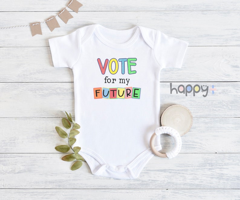 May include: White baby onesie with short sleeves featuring the text "VOTE for my FUTURE" in colorful block letters.