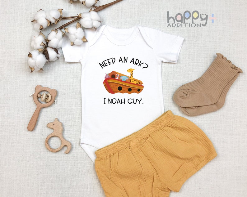 May include: White baby onesie with a cartoon ark and animals. The text reads "Need an ark? I Noah guy."