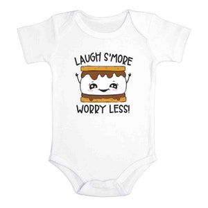 Pu&ograve; includere: Body bianco per neonato con un grafico di s'more a cartone animato e il testo "Laugh S'more Worry Less!"