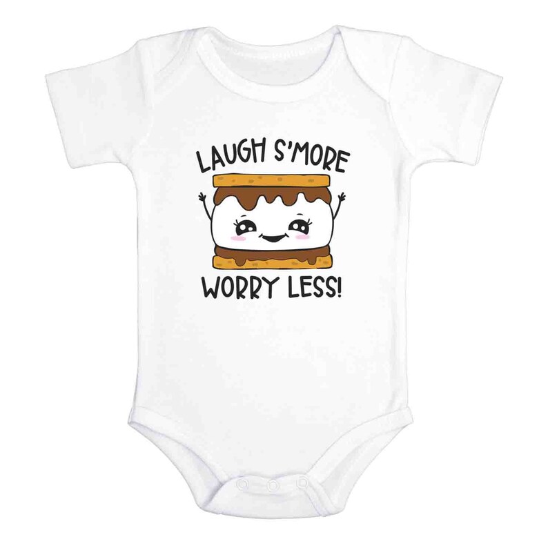Pu&ograve; includere: Body bianco per neonato con un grafico di s'more a cartone animato e il testo "Laugh S'more Worry Less!"