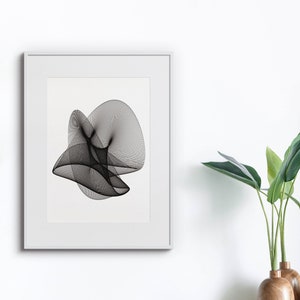 Può includere: Una stampa di arte astratta in bianco e nero in una cornice bianca, appesa a una parete bianca. Una pianta verde in vaso si trova su uno scaffale di legno sotto la stampa.