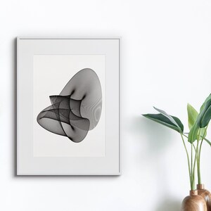 Puede incluir: Una impresión de arte abstracto en blanco y negro en un marco blanco. La impresión presenta una serie de líneas curvas superpuestas que crean una sensación de movimiento y profundidad.