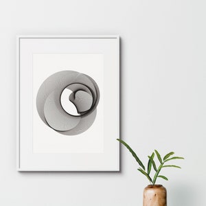 Pode incluir: Um design geométrico abstrato em preto e branco em uma moldura branca em uma parede branca. Uma pequena planta em vaso com folhas verdes está em primeiro plano.