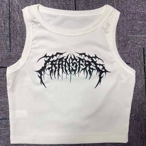 Op de afbeelding: Witte geribbelde tanktop met een zwarte grafische print van het woord "FANGS" in een gotisch lettertype.