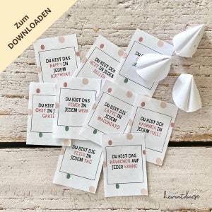 May include: A set of eight white cards with pink and green polka dots. Each card has a different phrase written on it in German. The phrases are: "Du bist das Happy in jedem Birthday", "Du bist der Best in jeden Seller", "Du bist das Feuer in jedem Werk", "Du bist die Latte in jedem Macchiato", "Du bist der Kashmir in jedem Pulli", "Du bist das Obst in jedem Garten", "Du bist die Feier in jedem Tag", "Du bist das Häubchen auf jeder Sahne".