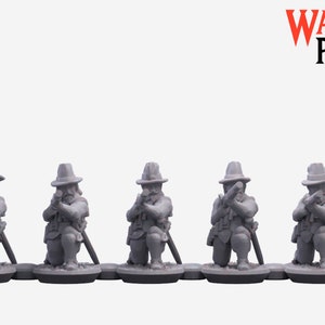 May include: Five gray plastic miniature figures of soldiers kneeling and holding rifles. The figures are wearing hats and are posed in a line.