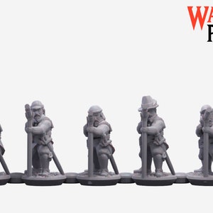 May include: Five gray plastic miniature figures of people wearing hats and holding spears. The figures are standing on small round bases.
