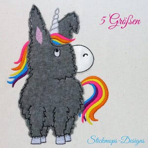 May include: Embroidered grey donkey with a rainbow mane and tail. The donkey has a white horn and a white face with a pink ear. The text "5 Größen" is in the top right corner of the image.