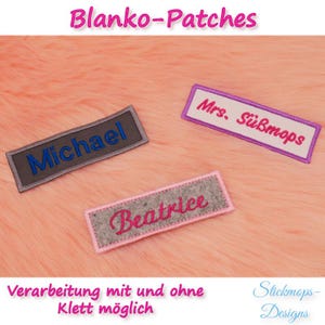 Könnte beinhalten: Drei graue Filznamenspatches mit rosa, lila und grauer Naht. Die Patches liegen auf einer rosa flauschigen Oberfläche. Die Patches lauten "Michael", "Beatrice" und "Mrs. Süßmops". Der Text "Verarbeitung mit und ohne Klett möglich" befindet sich am unteren Rand des Bildes. Der Text "Stickmops-Designs" befindet sich unten rechts im Bild.
