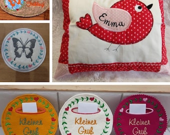May include: Three embroidered felt circles with a small pocket and the text "Kleiner Gruß" in white. The circles are in yellow, white, and pink.