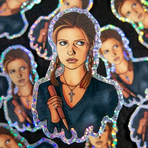 Buffy Summers sticker with glitter border and details. She is wearing a glittery cross and holding a wooden stake. More stickers are behind her.