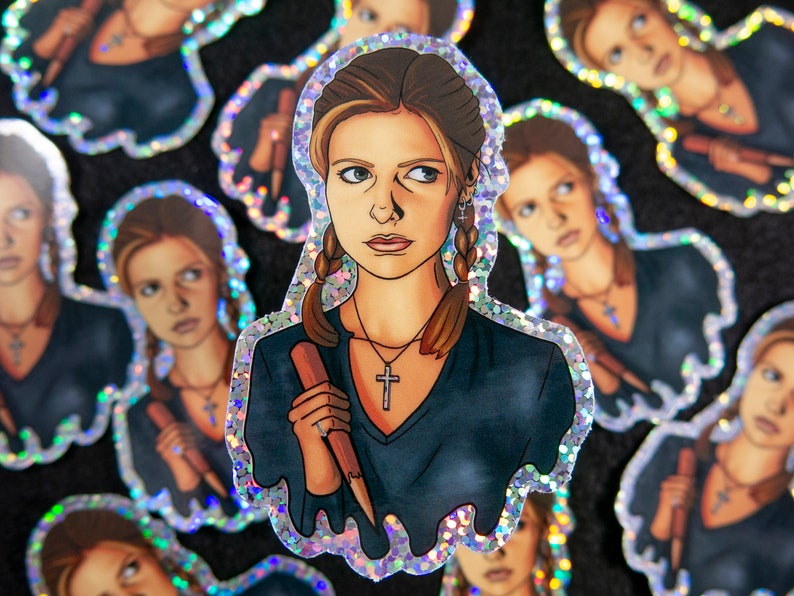 Buffy Summers sticker with glitter border and details. She is wearing a glittery cross and holding a wooden stake. More stickers are behind her.