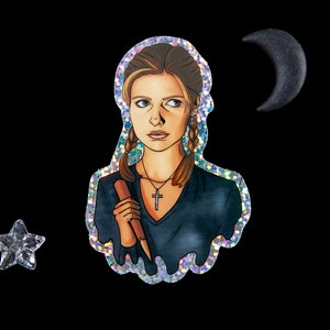 Buffy Summers sticker with glitter border and details. She is wearing a glittery cross and holding a wooden stake. There is a small star and half moon sitting next to the sticker.