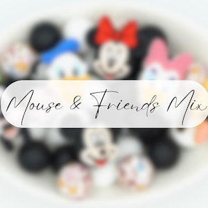 Op de afbeelding: Een verzameling kleurrijke kralen met stripfiguren, waaronder Mickey Mouse, Minnie Mouse, Donald Duck en Pluto. De kralen liggen in een witte kom, met de tekst "Mouse & Friends Mix" eroverheen.