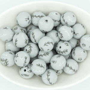 Peut inclure: Un bol de perles en silicone grises avec un motif floral blanc et gris.