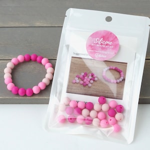 May include: A pink silicone DIY bracelet kit with a suggested bracelet design on the packaging. The kit includes a variety of pink silicone beads.