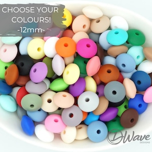 Peut inclure: Un bol rempli de perles en silicone colorées, chacune mesurant 12 mm de diamètre. Les perles sont dans différentes nuances de bleu, vert, rouge, jaune, orange, rose, marron et blanc. Choisissez vos couleurs ! -12mm-