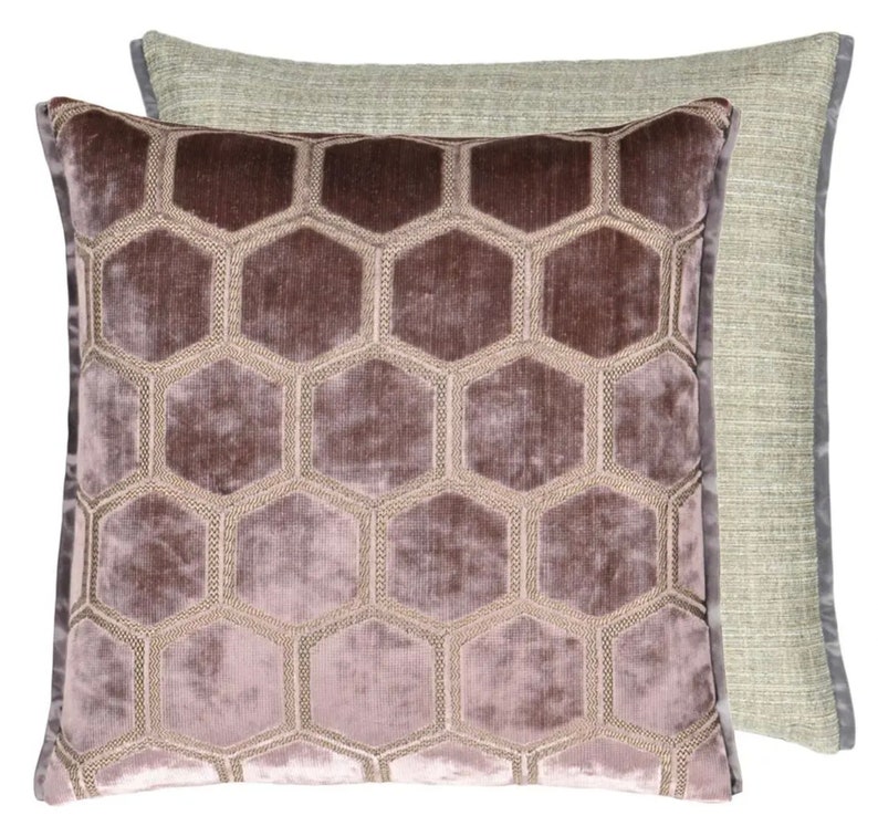 May include: A decorative throw pillow with a geometric pattern of hexagons in a light purple color. The pillow has a light green backing.