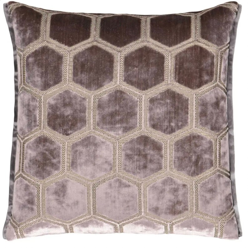 May include: A decorative throw pillow with a geometric pattern of hexagons in a light gray and brown color scheme.