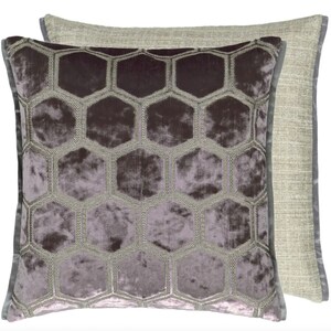 May include: A square throw pillow with a geometric pattern of hexagons. The pillow is made of a soft, plush fabric with a subtle sheen. The hexagons are embroidered in a contrasting color, creating a raised texture. The pillow has a light gray backing.