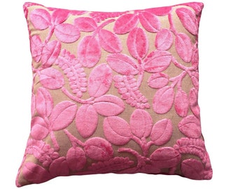 Pode incluir: Travesseiro de veludo rosa com um padrão floral. O travesseiro tem um fundo bege com folhas e flores rosas.