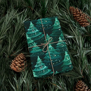 May include: A green gift wrap with a pattern of stylized Christmas trees. The paper is tied with twine and is sitting on a bed of pine needles.