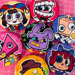 Puede incluir: Una colección de siete chapas redondas con ilustraciones de personajes de dibujos animados coloridos, incluyendo un bufón, una criatura con dientes, un robot, un conejo morado, una forma triangular rosa, una muñeca y una figura amarilla con sombrero.
