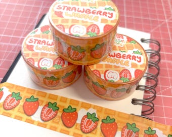 May include: Three rolls of washi tape with a strawberry waffle pattern. The tape is orange and yellow with red strawberries and the text "Strawberry Waffle" printed on the tape.