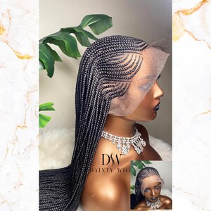 May include: A black braided wig with a lace front is displayed on a mannequin head. The wig features intricate braiding patterns and long, flowing braids. The mannequin is wearing a sparkling necklace. The image includes a smaller inset image of the wig.