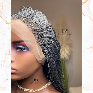 May include: A close-up of a mannequin head featuring a gray and black braided wig with a lace front. The wig is styled with small, individual braids. The mannequin is wearing a rhinestone necklace. The text "DSW DAINTY WIGS" is visible.