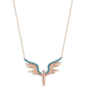 May include: A rose gold necklace with a turquoise stone angel wing pendant. The wings are detailed with small turquoise stones and the pendant is shaped like a pointed arrow.