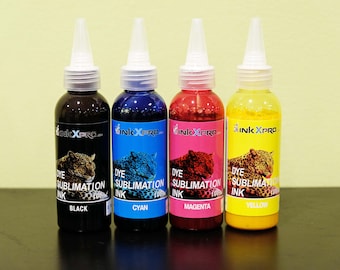 Peut inclure: Quatre bouteilles d'encre de sublimation InkXpro noire, cyan, magenta et jaune. Chaque bouteille a un embout blanc et une étiquette avec une image de léopard et le nom de la couleur de l'encre. Les bouteilles sont sur une surface noire.