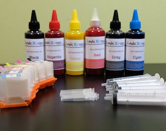 May include: A collection of ink bottles in black, magenta, yellow, red, gray, and cyan, with matching color-coded labels. Also includes a printer cartridge, syringes, and small plastic pieces. The bottles are labeled "Ink X Pro Dye Sublimation Ink."