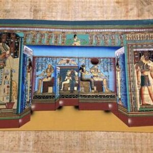 May include: A colorful painting on papyrus depicting an ancient Egyptian scene. The artwork features pharaohs, hieroglyphs, and intricate architectural details in shades of blue, gold, and brown. The painting is rectangular and appears to be displayed on a textured surface.