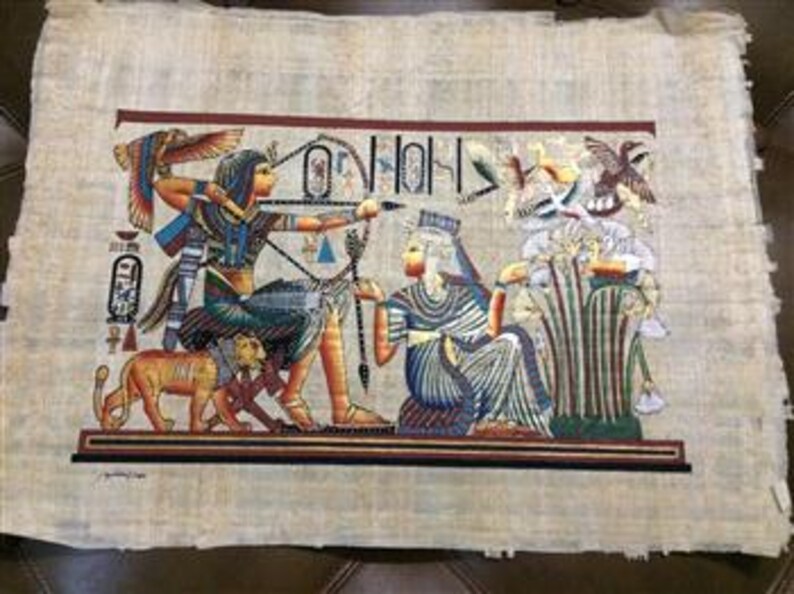 May include: A colorful papyrus painting depicting an ancient Egyptian scene. The artwork features figures with detailed clothing and accessories, including a bow and arrow, set against a backdrop of hieroglyphs and birds. The painting is on a textured, beige papyrus sheet.