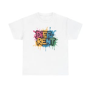 May include: White t-shirt with the word "DIFFERENT" in a graffiti-style design. The word is in a variety of colors, including pink, yellow, blue, and green, with a black outline. The background features colorful paint splatters.